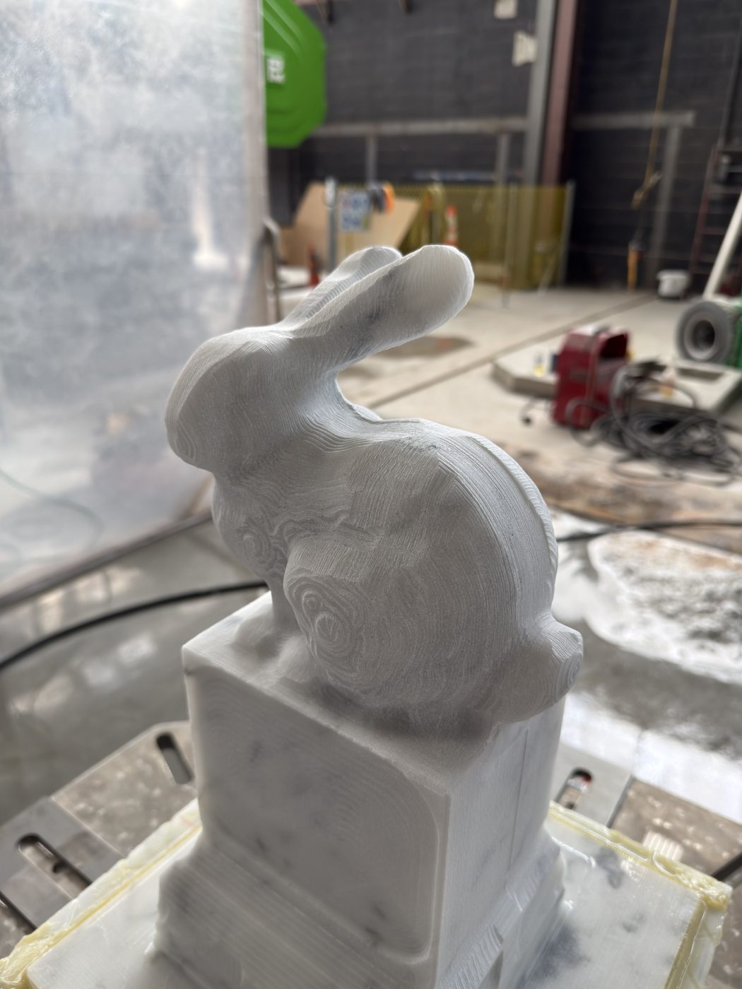 Roughed marble bunny on its pedestal.